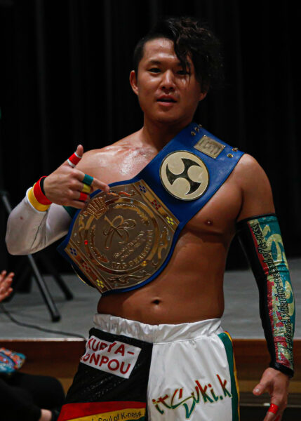 Dragongate's U-T shows off his tag team title belt