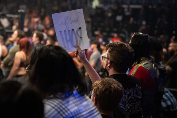 A fan, loosely sporting a protective mask, holds up a "Thank you, ROH" sign 