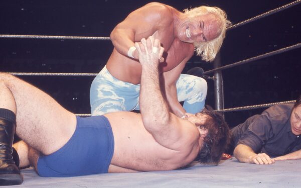 Superstar Graham has Bruno Sammartino on the mat, as the WWWF official looks on (1977)