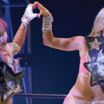 Rose Gold (Mina Shirakawa & Mariah May) celebrate with their signature hands-making-a-heart pose, the Goddesses of Stardom title belts, and the corresponding championship trophy